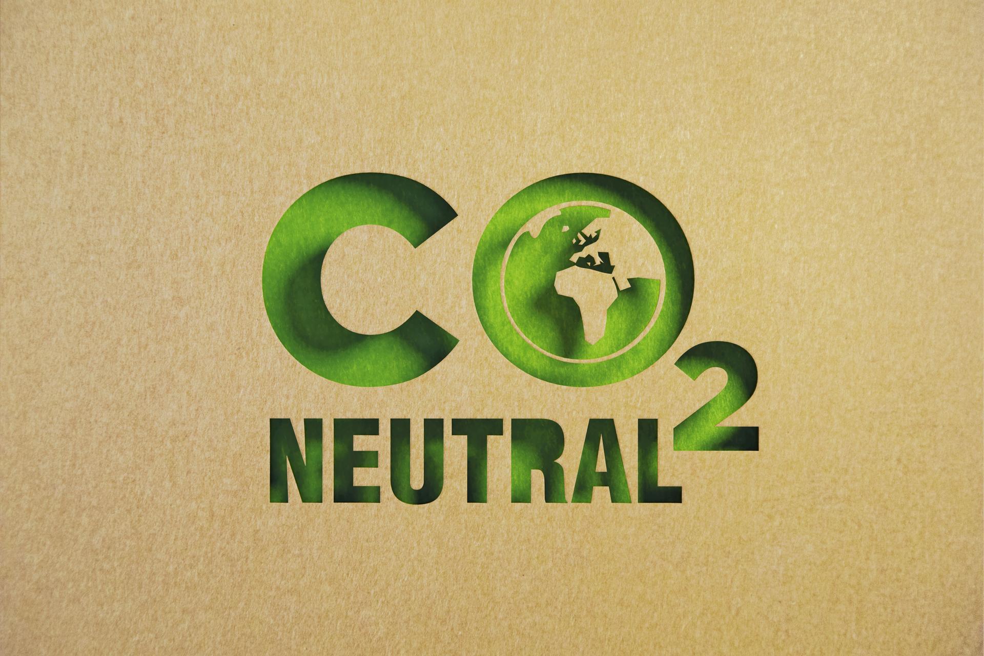 Carbon Neutrality Concept - CO2 Neutral Made of Recycled Paper Sitting On Green Background